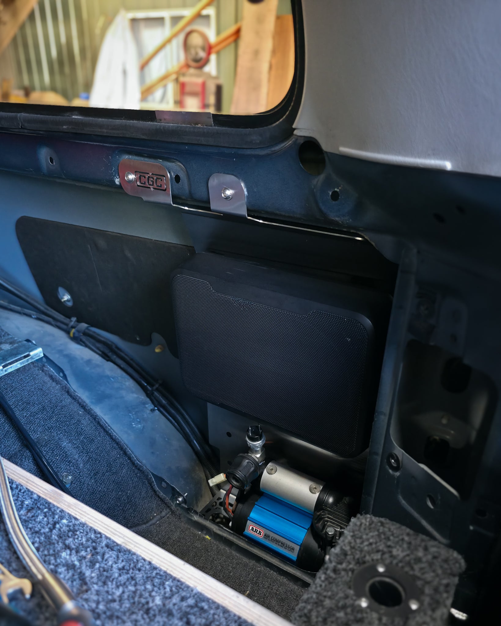 Laser-cut rear quarter panel mount for Toyota LandCruiser 80 Series supporting ARB twin and single air compressors with room for concealed subwoofer.